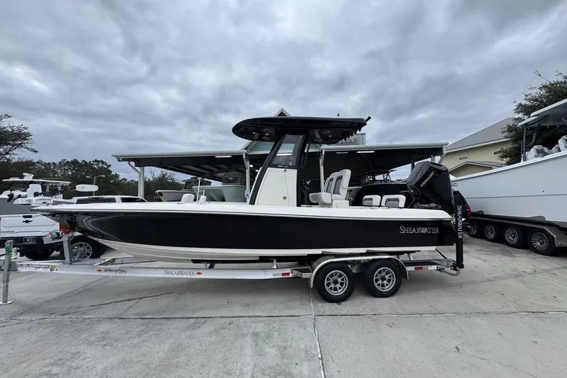The Image of 2026 ShearWater 260 Carolina Flare boat on trailer, parked outdoors under cloudy sky. - 1