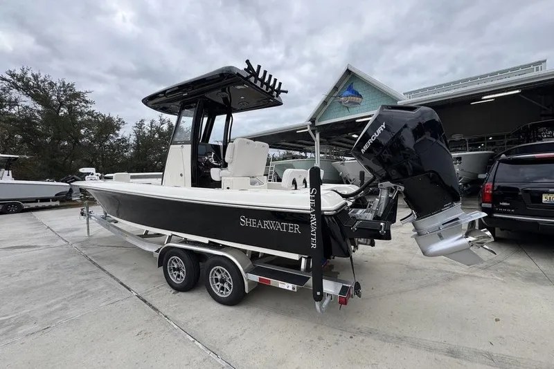 Slide: The Image of 2026 ShearWater 260 Carolina Flare boat on trailer, featuring Mercury outboard motor. - 16