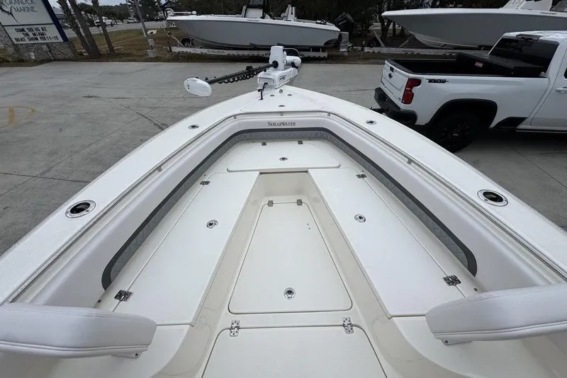 Slide: The Image of 2026 ShearWater 260 Carolina Flare boat, white deck, parked near a white truck. - 18