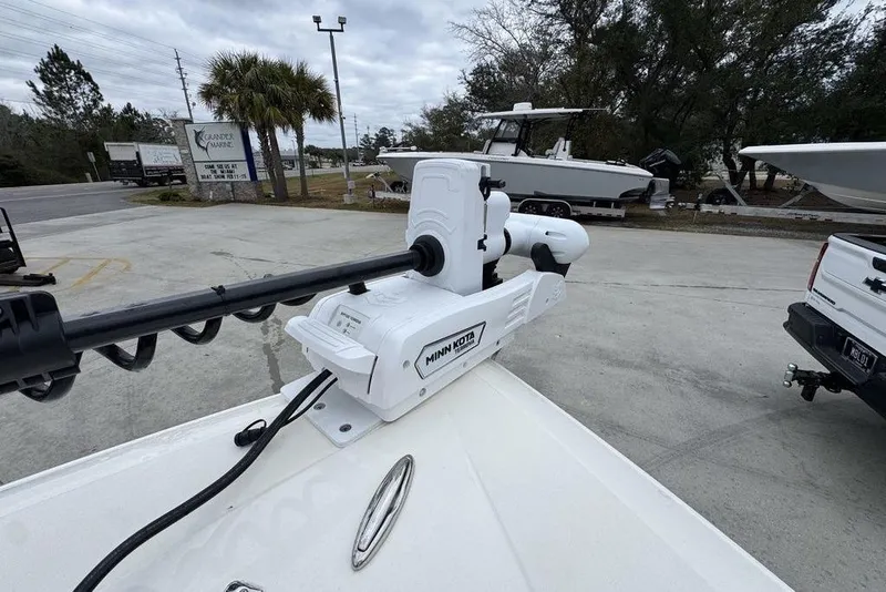 Slide: The Image of 2026 ShearWater 260 Carolina Flare boat with Minn Kota trolling motor in a marina setting. - 20