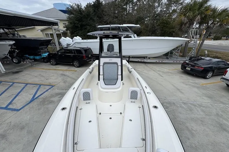 Slide: The Image of 2026 ShearWater 260 Carolina Flare boat in a marina, surrounded by vehicles and other boats. - 22