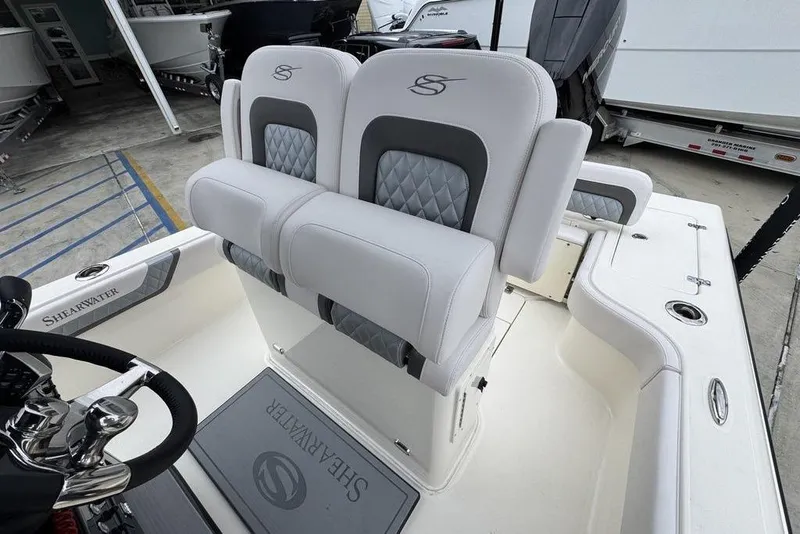 Slide: The Image of 2026 ShearWater 260 Carolina Flare boat interior with luxury seating and steering wheel. - 26