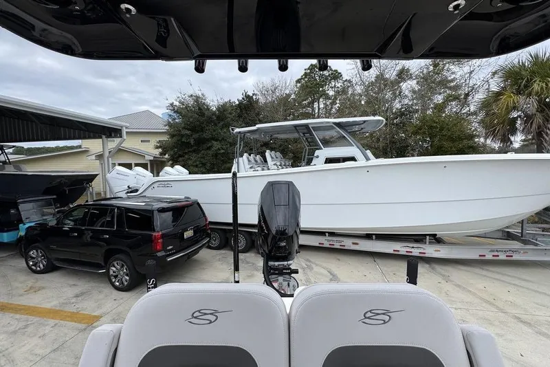 Slide: The Image of 2026 ShearWater 260 Carolina Flare boat on trailer beside black SUV. - 28