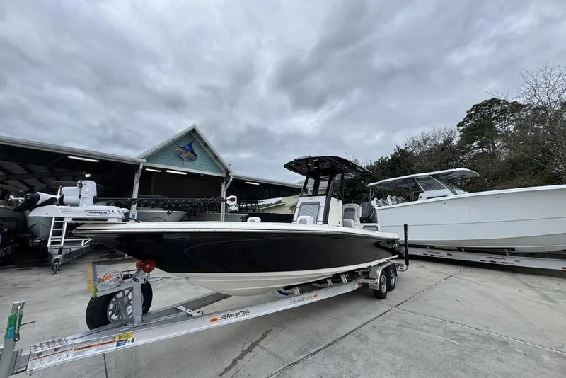 Slide: The Image of 2026 ShearWater 260 Carolina Flare boat on trailer, parked outdoors under cloudy sky. - 3