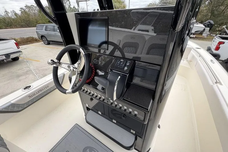 Slide: The Image of 2026 ShearWater 260 Carolina Flare boat console with steering wheel and control panel. - 33