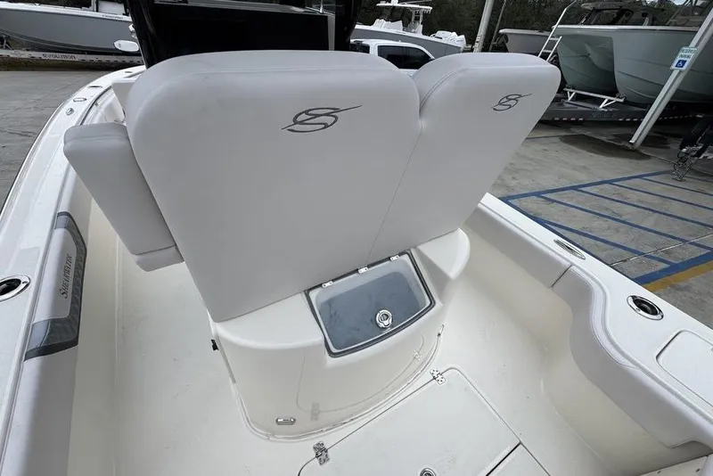 Slide: The Image of 2026 ShearWater 260 Carolina Flare boat interior with cushioned seating and storage compartment. - 35