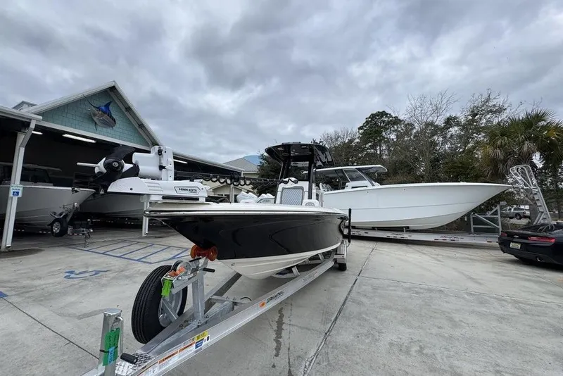 Slide: The Image of 2026 ShearWater 260 Carolina Flare boat on trailer at marina, cloudy sky background. - 4