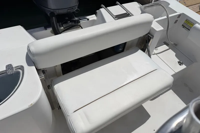 Slide: The Image of 2015 Sportsman Open 212 Center Console boat seating area with white cushioned bench. - 11