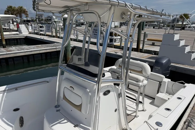 Slide: The Image of 2015 Sportsman Open 212 Center Console boat docked at marina, featuring sleek design and seating. - 9