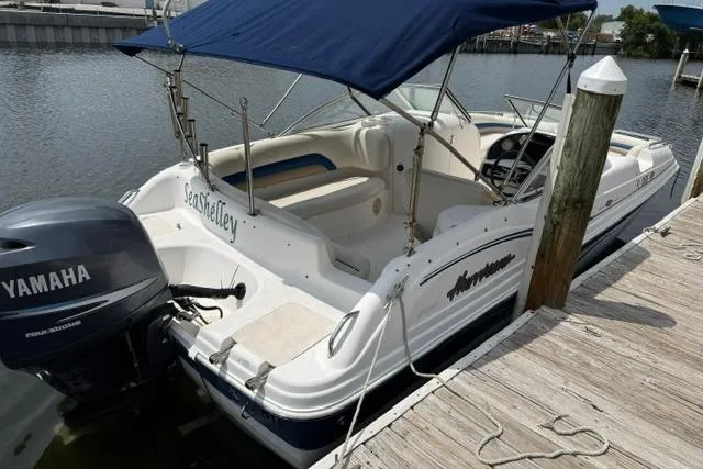 Slide: The Image of 2005 Hurricane SunDeck 217 OB boat docked, featuring Yamaha outboard motor and blue canopy. - 4