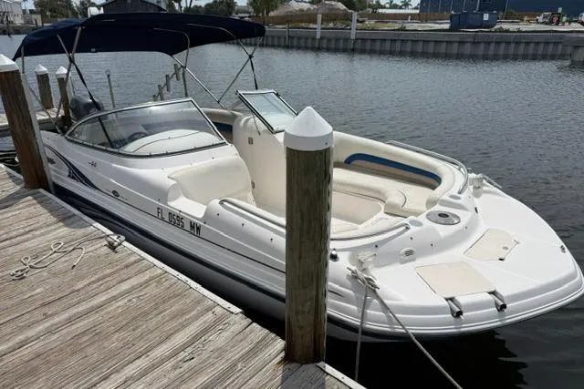 Slide: The Image of 2005 Hurricane SunDeck 217 OB boat docked at a marina, featuring a sleek white design. - 5