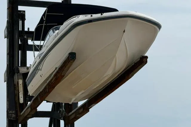 Slide: The Image of 2005 Hurricane SunDeck 217 OB boat lifted on a dock hoist. - 7