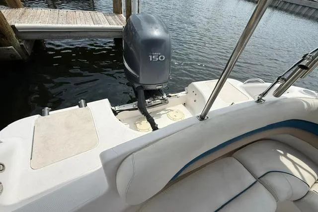 Slide: The Image of 2005 Hurricane SunDeck 217 OB boat with Yamaha 150 outboard motor docked by water. - 8