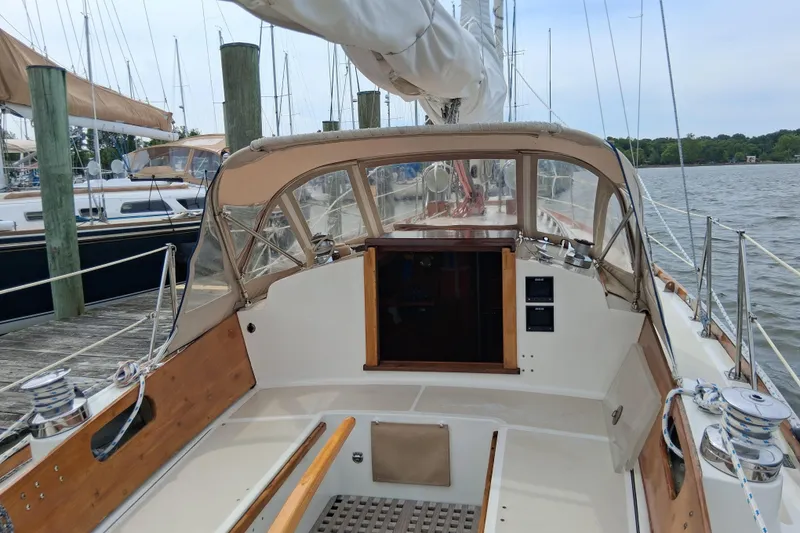 Slide: The Image of 1967 Hinckley Pilot 35 sailboat cockpit with wooden accents, docked at a marina. - 11