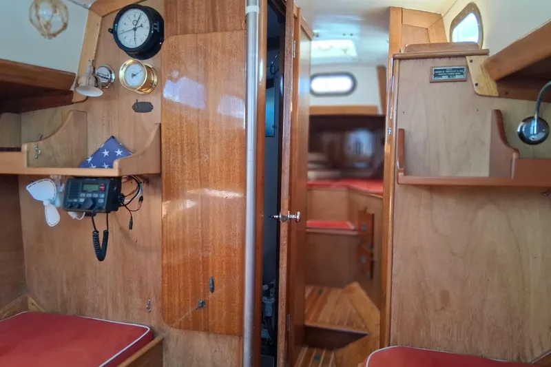 Slide: The Image of Interior of a 1967 Hinckley Pilot 35 sailboat with wooden cabinetry and red cushions. - 15