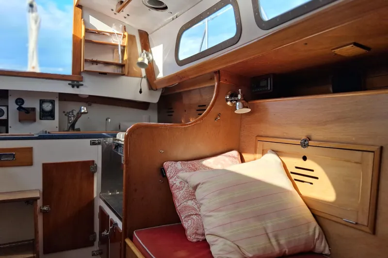 Slide: The Image of Interior of a 1967 Hinckley Pilot 35 sailboat, featuring cozy wooden cabin and cushions. - 16