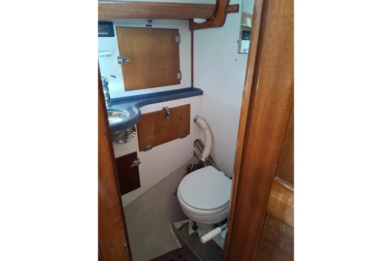 Slide: The Image of Hinckley Pilot 35 (1967) boat bathroom with wooden cabinets and compact toilet. - 19