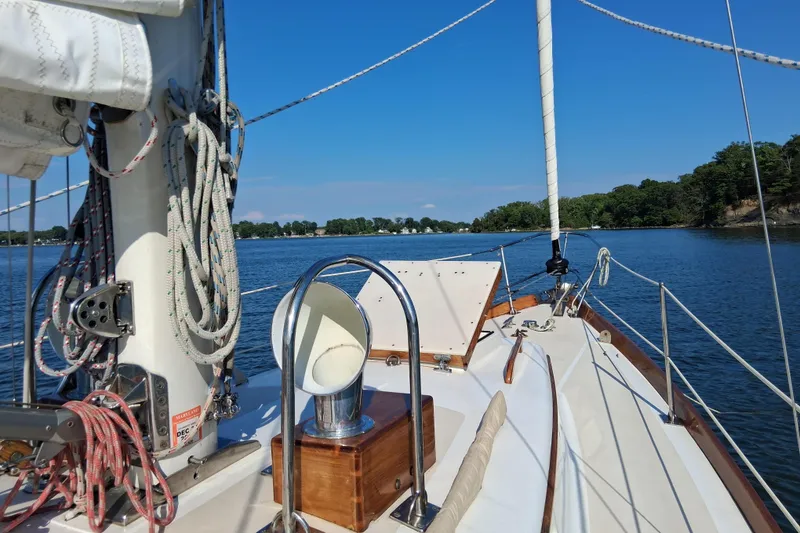 Slide: The Image of 1967 Hinckley Pilot 35 sailboat on calm water, showcasing deck and rigging. - 5