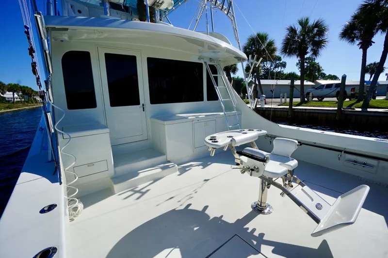 Slide: The Image of 1991 G&S 58 yacht deck with fishing chair, ladder, and storage, docked near palm trees. - 10