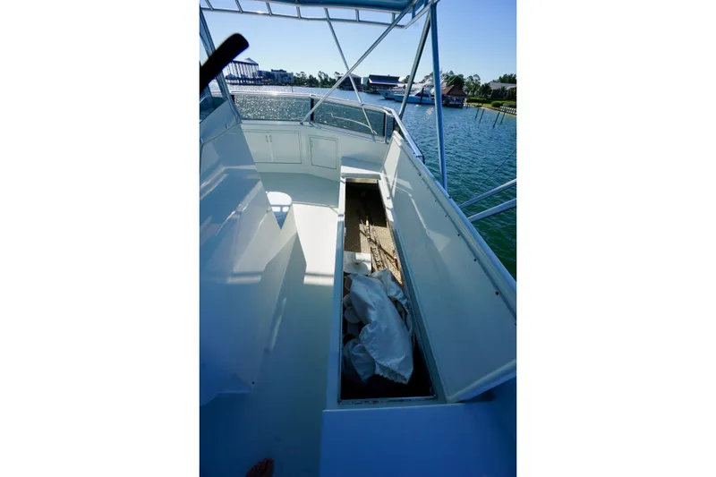 Slide: The Image of 1991 G&S 58 boat deck with open storage compartment, overlooking serene waterfront. - 17