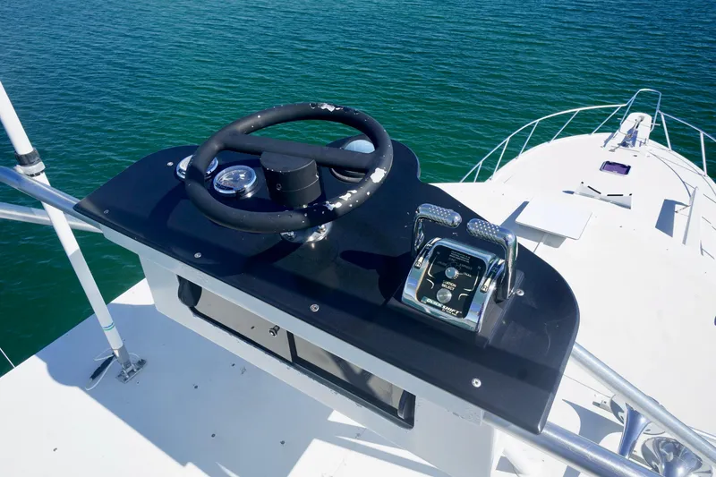 Slide: The Image of Helm of 1991 G&S 58 yacht with steering wheel and controls, overlooking blue water. - 22