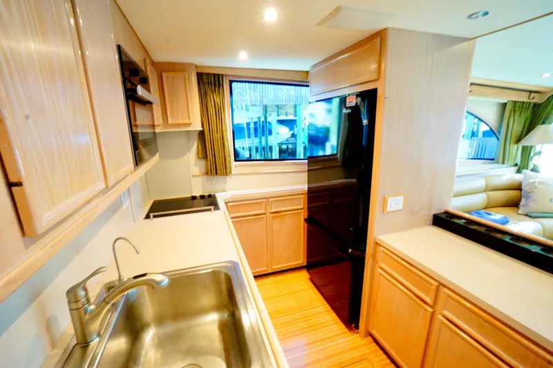 Slide: The Image of Modern kitchen interior in a 1991 G&S 58 yacht, featuring wooden cabinetry and stainless steel sink. - 33