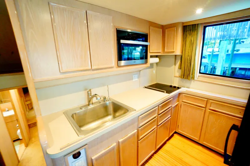 Slide: The Image of 1991 G&S 58 yacht kitchen with wooden cabinets, stainless steel sink, and window view. - 34