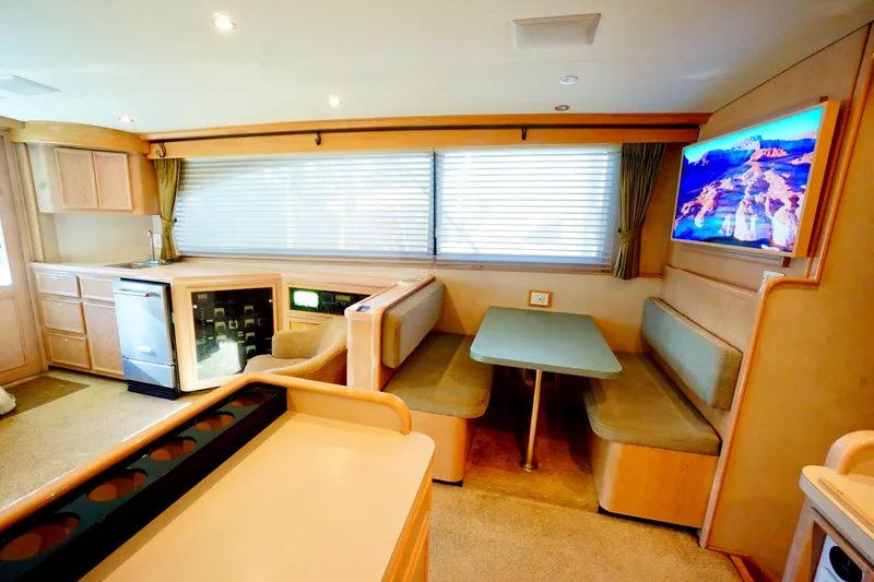 Slide: The Image of Luxurious 1991 G&S 58 yacht interior with dining area, kitchenette, and mounted TV. - 38