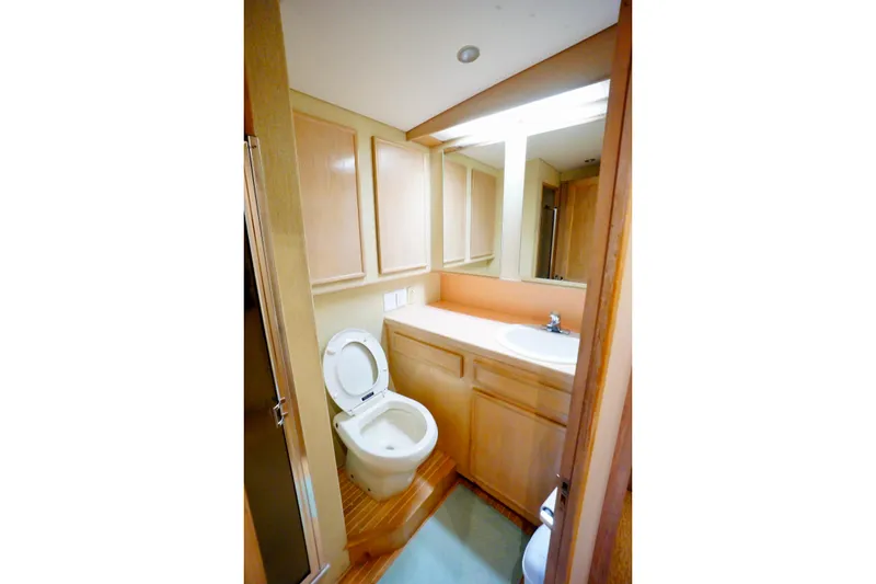 Slide: The Image of 1991 G&S 58 yacht bathroom with wooden cabinets, toilet, and sink. - 40