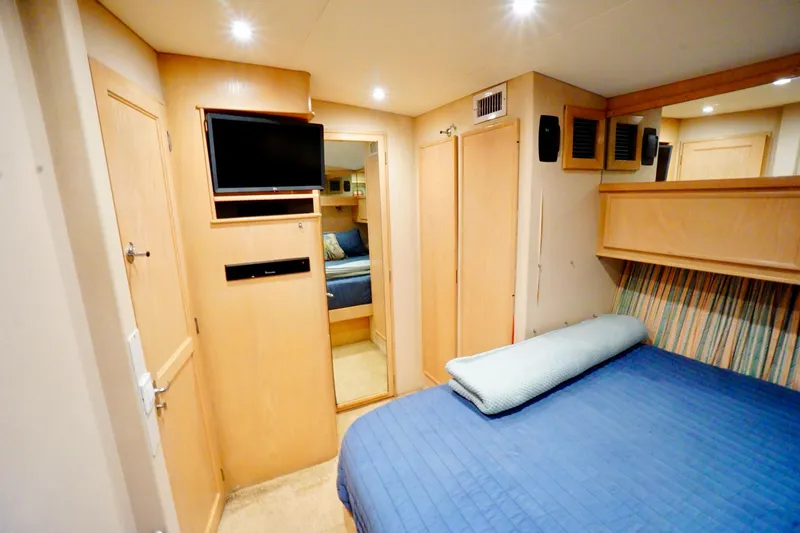Slide: The Image of Cozy bedroom in 1991 G&S 58 yacht with TV, blue bedding, and wooden cabinetry. - 44