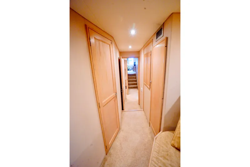 Slide: The Image of Narrow hallway inside 1991 G&S 58 yacht, featuring wooden doors and carpeted flooring. - 48