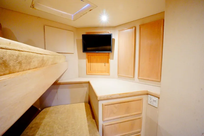 Slide: The Image of 1991 G&S 58 interior with bunk beds, TV, and wooden cabinetry. - 49