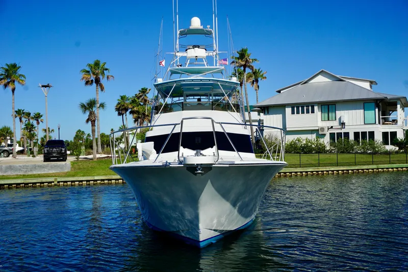 Slide: The Image of Front view of a 1991 G&S 58 yacht docked near a waterfront house. - 5