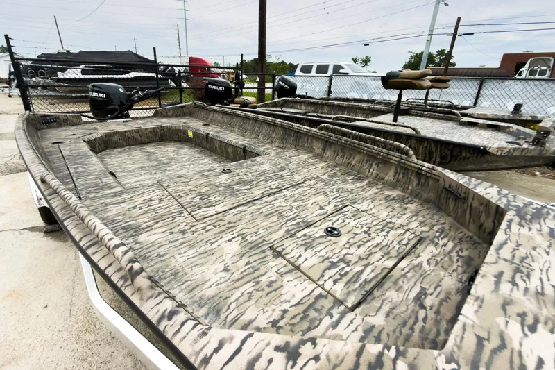 Slide: The Image of 2026 Excel 183 Tomahawk boat with camouflage design, parked outdoors. - 4