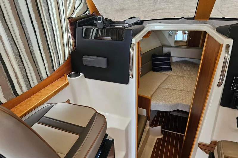 Slide: The Image of Interior of 2021 Cutwater C-28 boat, featuring cozy cabin with striped upholstery and seating. - 15