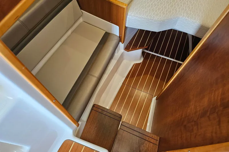 Slide: The Image of Interior of 2021 Cutwater C-28 boat featuring wooden flooring and cushioned seating. - 19