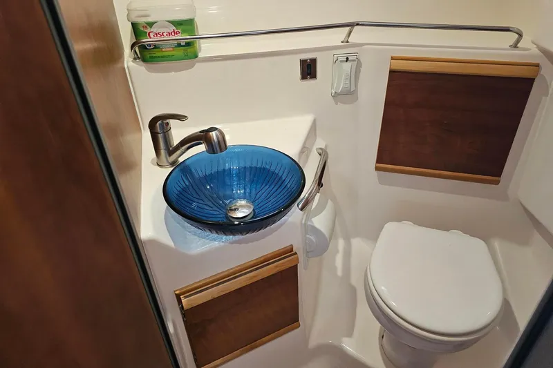 Slide: The Image of 2021 Cutwater C-28 boat bathroom with blue glass sink and toilet. - 22