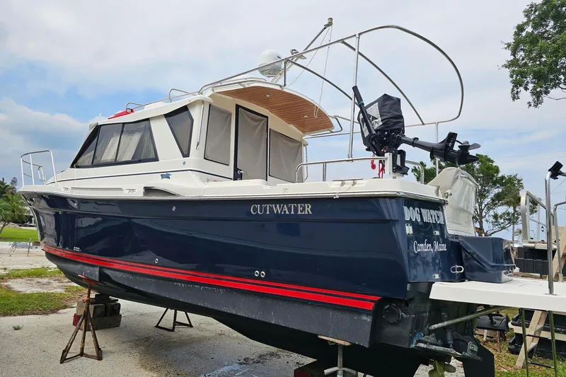 Slide: The Image of 2021 Cutwater C-28 boat on dry dock, featuring a sleek navy hull and white cabin. - 3