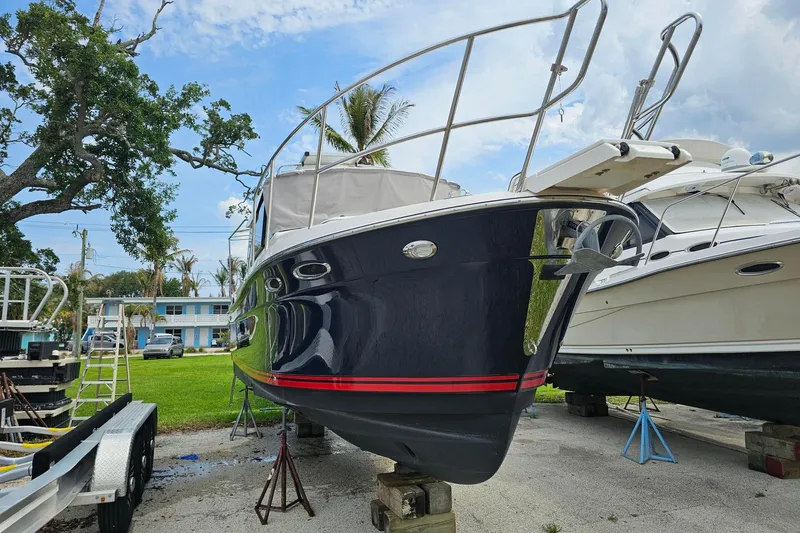 Slide: The Image of 2021 Cutwater C-28 boat on dry dock, surrounded by trees and other boats. - 4