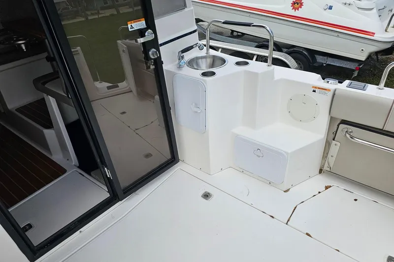 Slide: The Image of 2021 Cutwater C-28 boat interior with sink, storage compartments, and sliding door. - 8