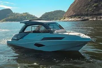 The Image of 2025 NX Boats NX350 MAXIMUS cruising on scenic waters with mountainous backdrop. - 1