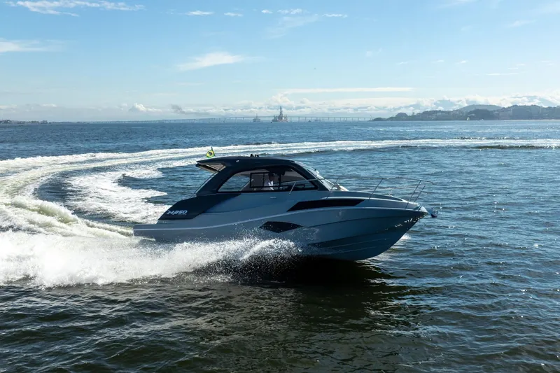 Slide: The Image of 2025 NX Boats NX350 MAXIMUS cruising on open water under a clear blue sky. - 11