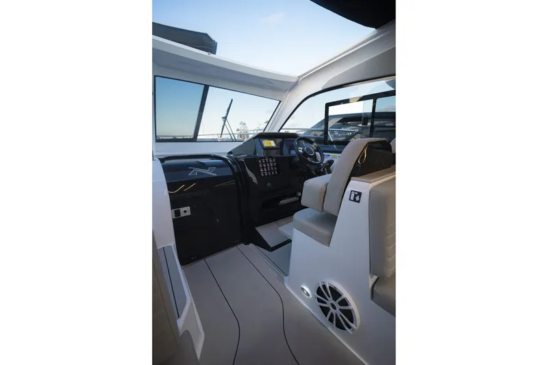Slide: The Image of Interior of 2025 NX Boats NX350 MAXIMUS, featuring modern helm and luxurious seating. - 18