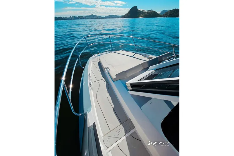 Slide: The Image of 2025 NX Boats NX350 MAXIMUS cruising on serene waters with scenic mountain backdrop. - 19