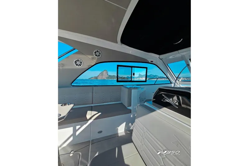 Slide: The Image of Interior view of 2025 NX Boats NX350 MAXIMUS, showcasing sleek design and ocean backdrop. - 6