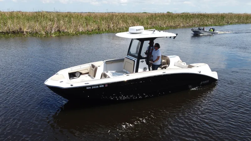 The Image of 2023 Yamaha Boats 255 FSH Sport E cruising on a calm river. - 0