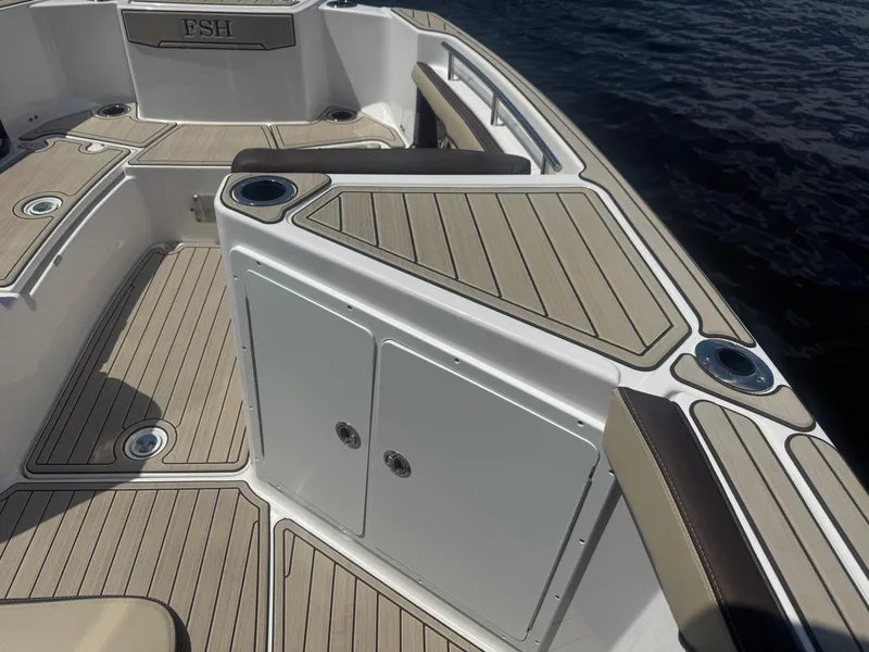 Slide: The Image of 2023 Yamaha Boats 255 FSH Sport E deck with sleek design and storage compartments. - 10