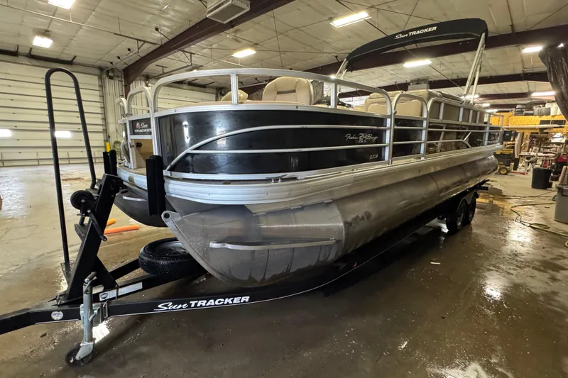 The Image of 2018 Sun Tracker Fishin' Barge 24 XP3 pontoon boat in a warehouse setting. - 1