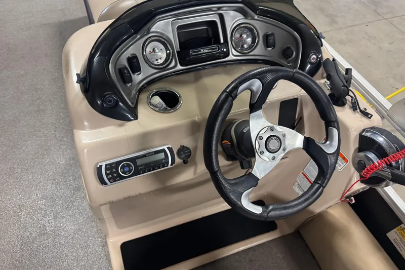 Slide: The Image of 2018 Sun Tracker Fishin' Barge 24 XP3 dashboard with steering wheel and controls. - 11