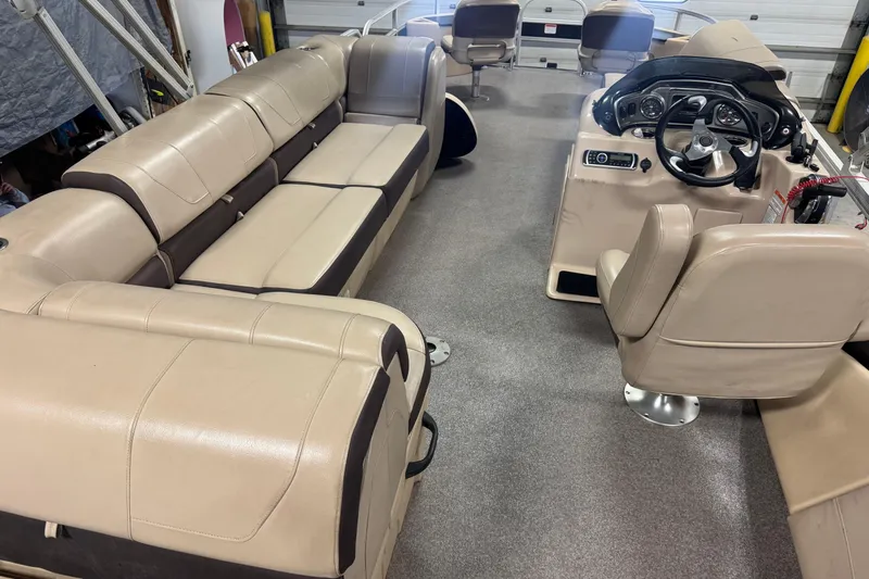 Slide: The Image of 2018 Sun Tracker Fishin' Barge 24 XP3 interior with beige seating and steering console. - 17